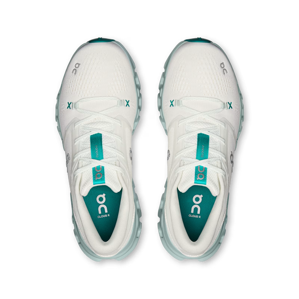 A pair of white On Cloudrunning sneakers shown from a top-down view, featuring teal accents on the inner lining, tongue, and outsole.