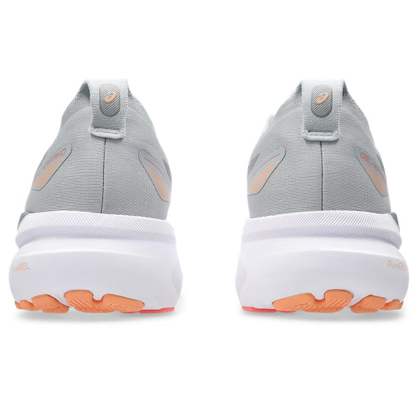 Gray athletic shoes with white soles and orange accents on a white background