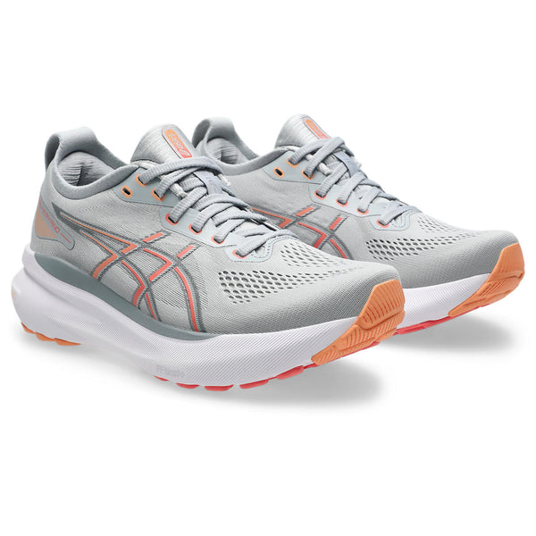 Gray running shoes with orange soles on a white background