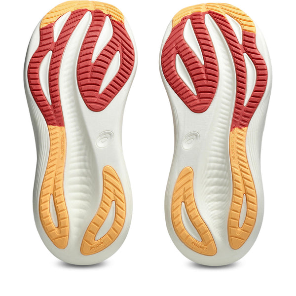 Close-up of a pair of white athletic shoes with red and orange sole pattern on a white background.