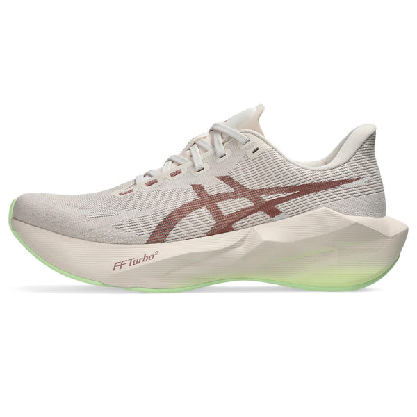 Beige running shoes with green accents on a white background