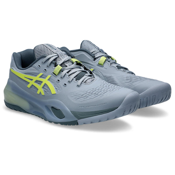 Gray running shoes with green accents on a white background