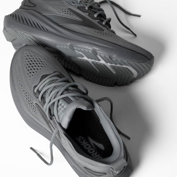 Gray athletic shoes with laces on a light gray background