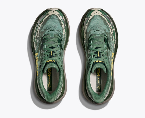 Green running shoes with brand logo on a white background