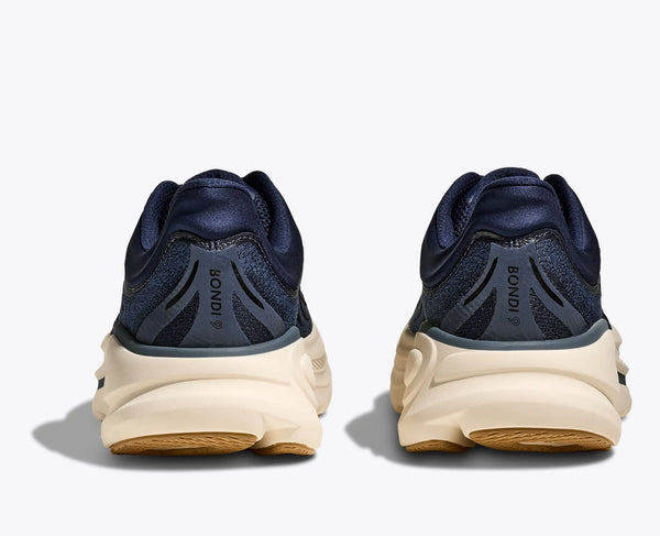 Navy running shoes with beige soles on a white background