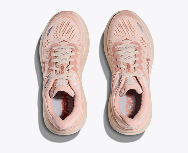 A pair of light pink Hoka Bondi 9 running shoes on a white background