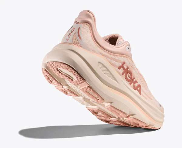 Pink running shoe with 'Hoka' branding on a white background and a durable outsole.