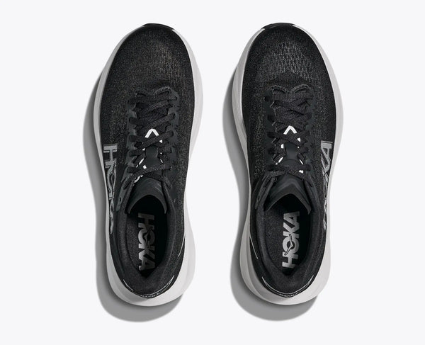 Black running shoes with white soles on a light gray background
