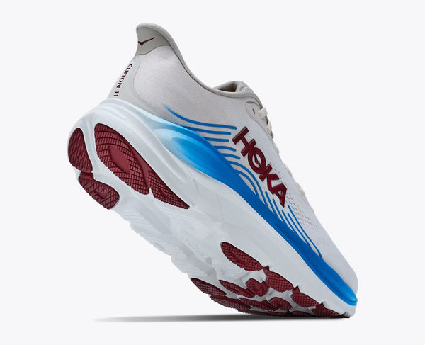 White running shoe with blue and red sole on a white background
