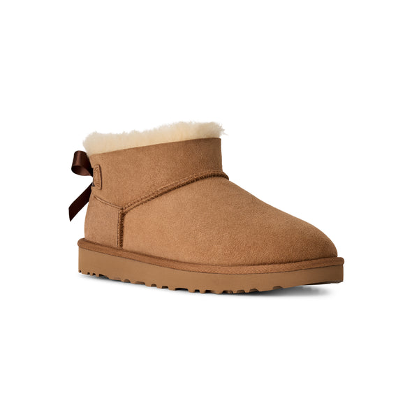 Tan ankle length slipper boot with a bow on the back
