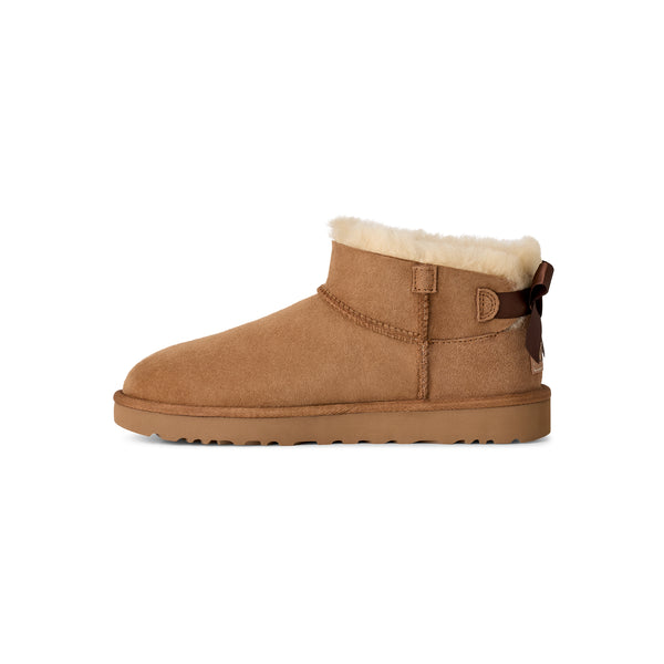 Tan ankle length slipper boot with a bow on the back