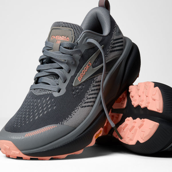 A pair of Brooks Adrenaline GTS trail running shoes in dark gray and black with coral pink accents, shown on a light gray background.