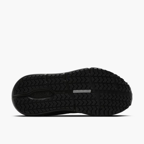 The black rubber outsole of a shoe, showing the tread pattern and a small reflective strip, photographed against a light gray background.