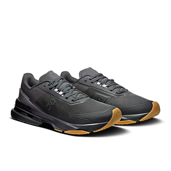 A black On running shoe with a textured mesh upper, black laces, a black midsole, and a contrasting brown outsole, on a white background.