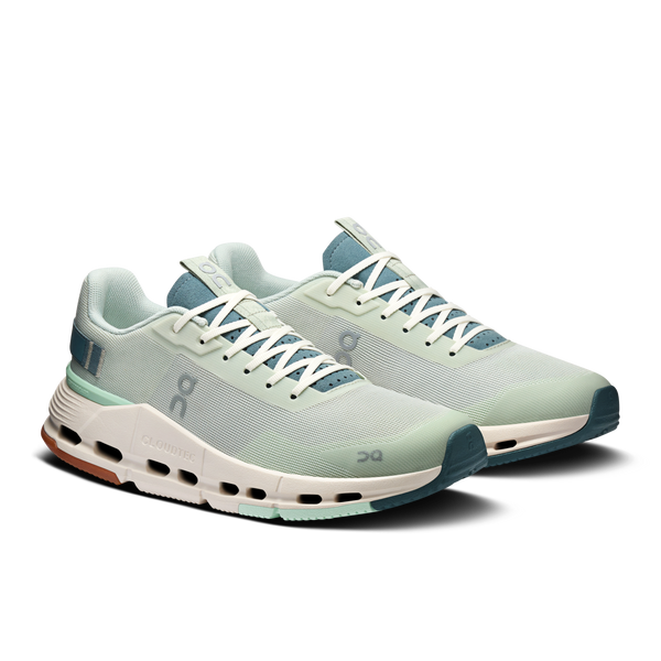 Pair of light green running shoes with white laces on a white background