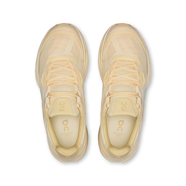 A pair of light cream/beige athletic sneakers shown from a top-down view on a solid white background. The shoes feature a breathable mesh upper, matching laces, and a thick cushioned sole, with the brand logo 'on' visible on the tongue and insole.