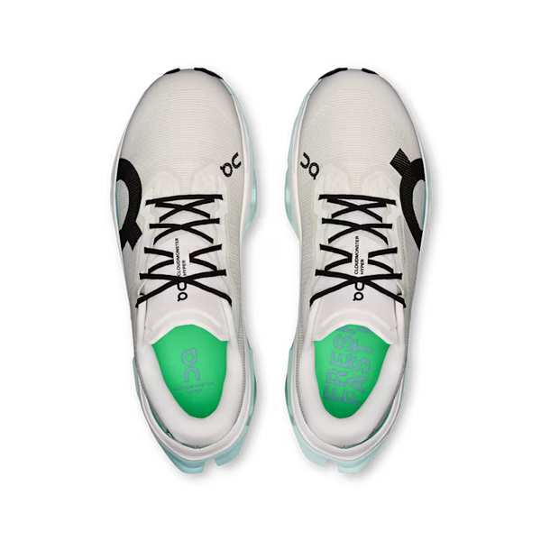 A pair of On running shoes shown from a top-down view, featuring a white mesh upper, black laces, a black On logo on the side, and a bright green tongue with 'FAST ON' printed on it.