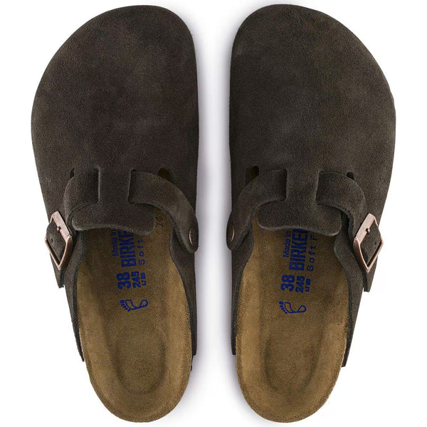 The upper of this shoe is dark brown and has brass buckles.