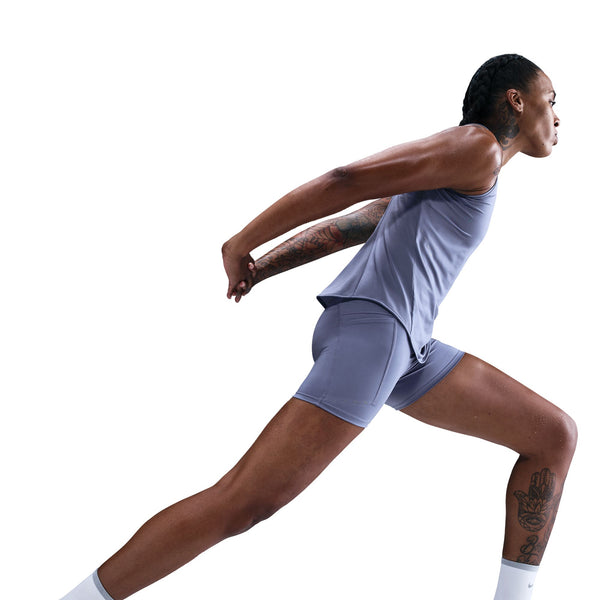 Person in athletic wear performing a dynamic pose on a white background