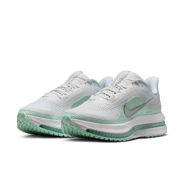 White and green running shoes with Nike logo on a white background.