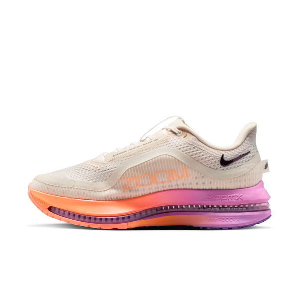 Beige running shoe with orange and purple sole on a white background