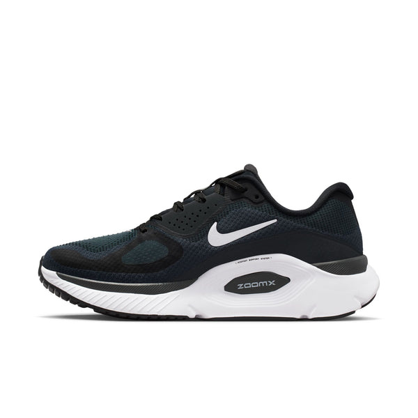 The medial side of a black and white Nike Structure plus with a focus on the midsole that provides extra stability.