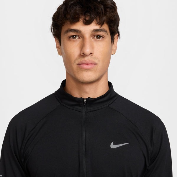 Man wearing a black Nike jacket on a light gray background