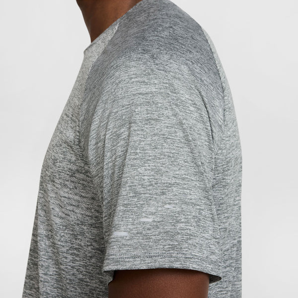 Gray t-shirt worn by a person on a white background