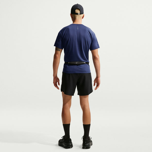Person wearing a blue athletic shirt and black shorts on a white background