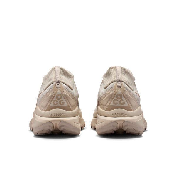Pair of beige sneakers with a brand logo on the back on a white background