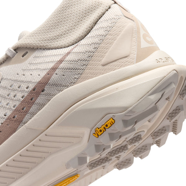 Close-up of a beige and brown shoe with 'Vibram' branding on a white background