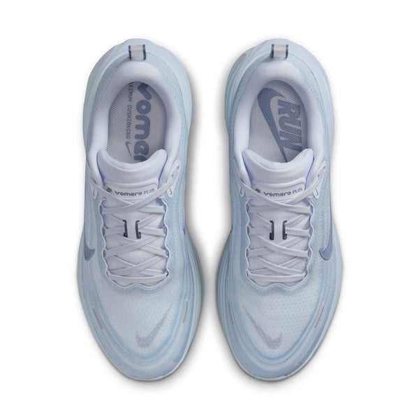 Pair of light blue sneakers with white soles on a white background from a top down view.