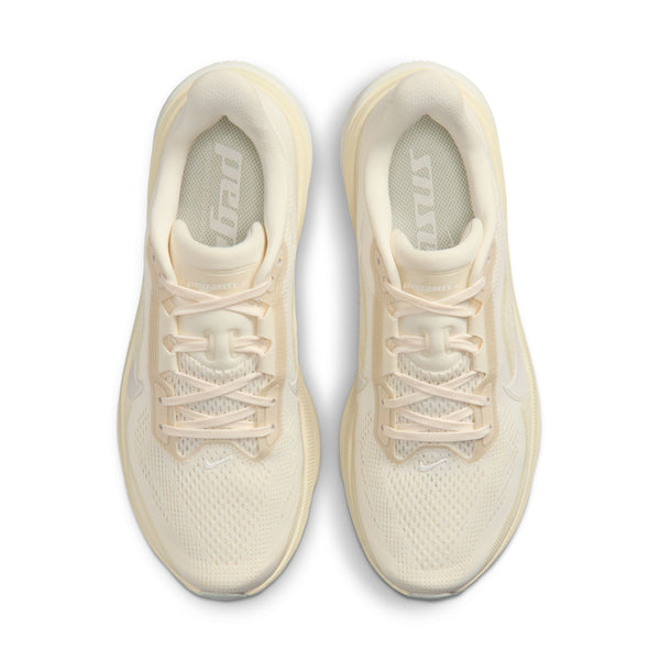 The top down view of a Nike pegasus 42 with a cream colored upper and laces.