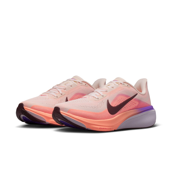 Pair of pink running shoes with a Nike logo on a white background
