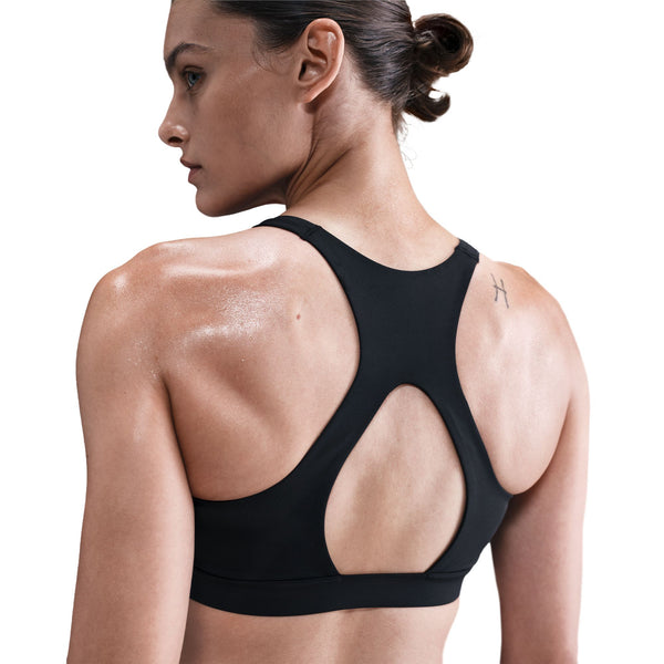 Woman wearing a black sports bra on a white background