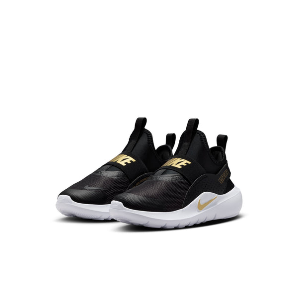 A pair of Nike children's sneakers in black with gold accents and white soles, displayed against a clean white background.