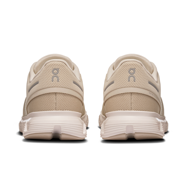 These beige and white On Cloud 6 shoes have the brand logo on the heel.