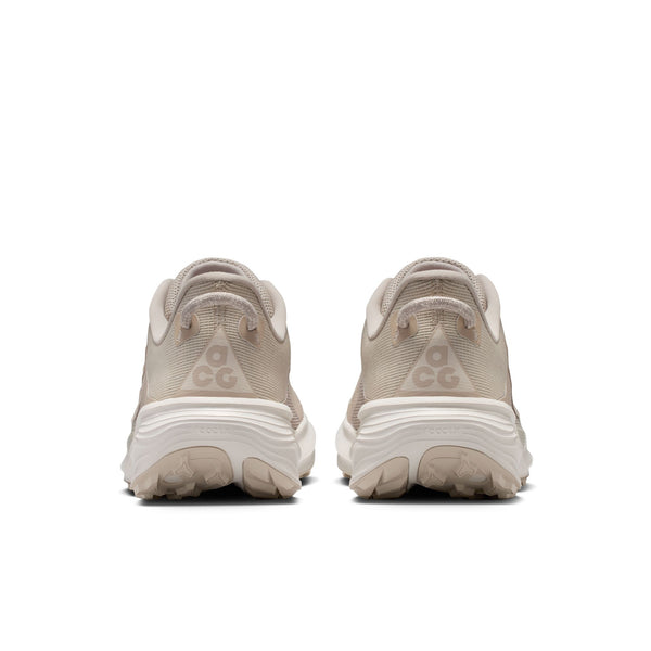 Pair of beige running shoes with 'ACG' branding on a white background