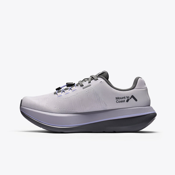 A light gray and purple running shoe with a dark gray sole and logo, featuring the text 'Mount to Coast' on the side