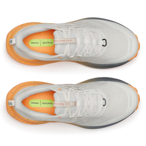 Gray running shoes with orange soles on a white background