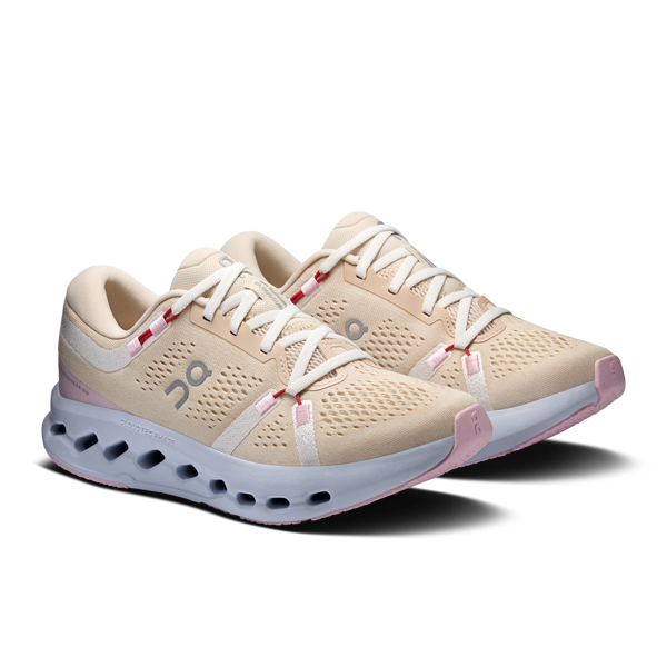 Pair of beige running shoes with white soles on a white background