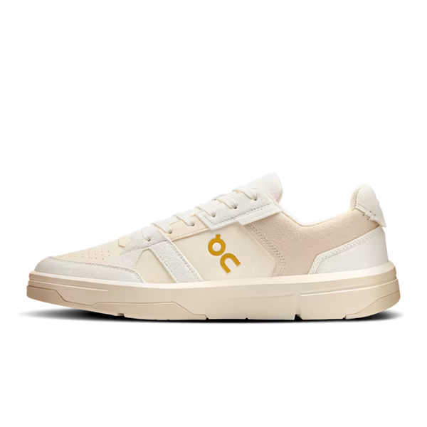 Beige sneaker with a yellow logo on a white background
