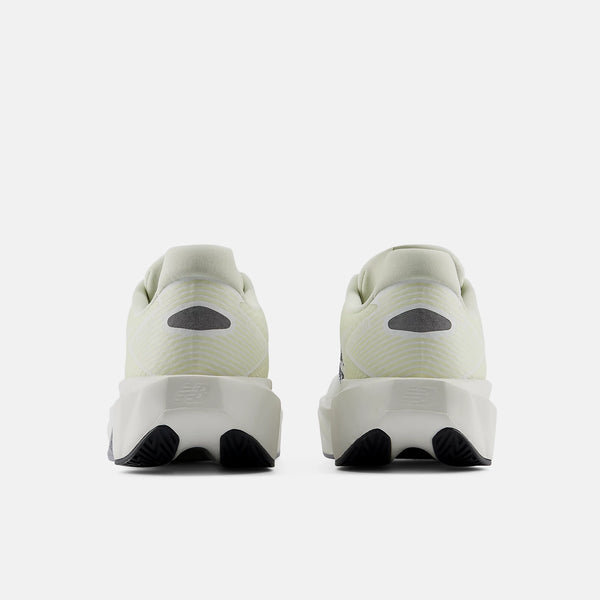 A pair of New Balance running shoes shown from the rear, featuring a light cream-colored upper, a chunky white midsole, and black outsole details, set against a plain light gray background.