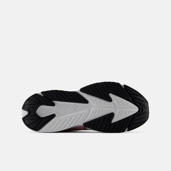 A close-up top-down view of a sneaker's black and white outsole, showing the textured tread pattern and New Balance logo embossed on the white section.