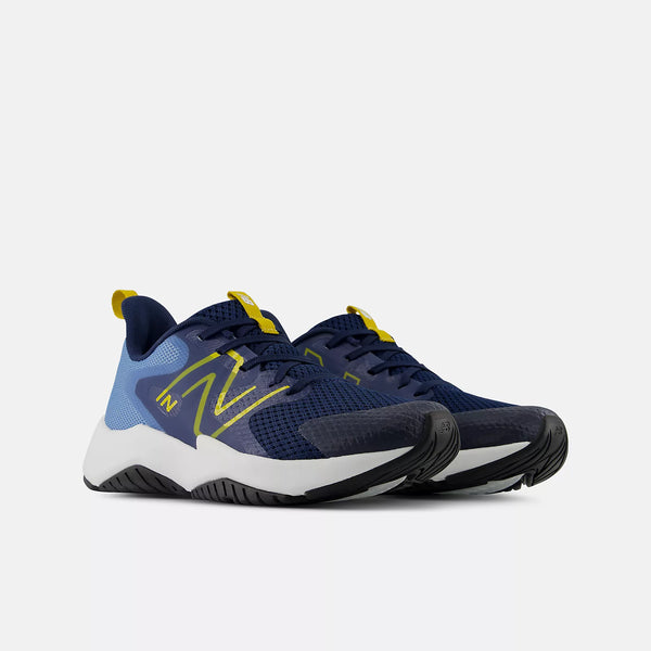 A pair of New Balance athletic sneakers in navy blue with light blue overlays, bright yellow accents on the logo and tongue, and a white midsole, shown against a light gray background.