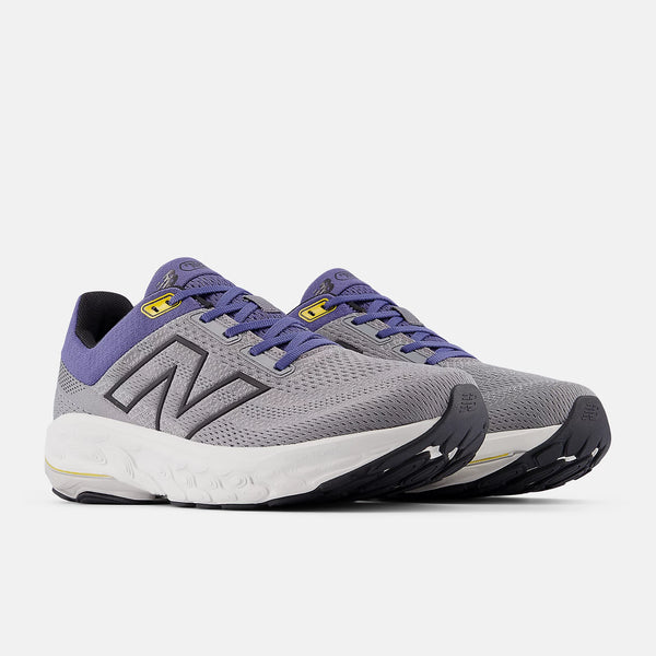 A pair of new balance shoes with blue laces and a white midsole.
