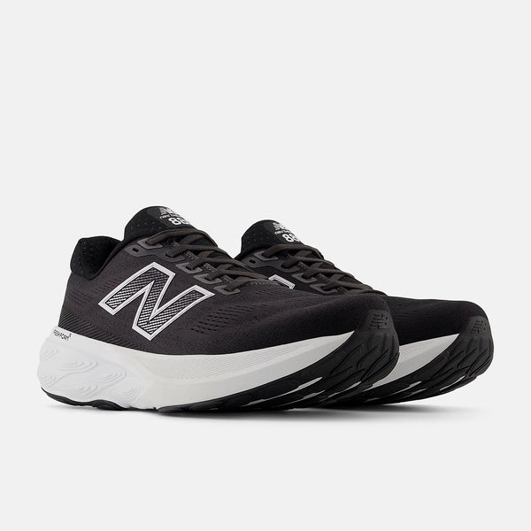 Black running shoes with white soles on a light gray background