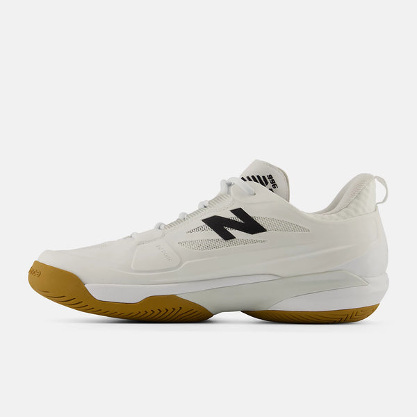 A New Balance tennis shoe in off-white with a black 'N' logo on the side and a brown gum outsole, shown in a side profile view against a light gray background.