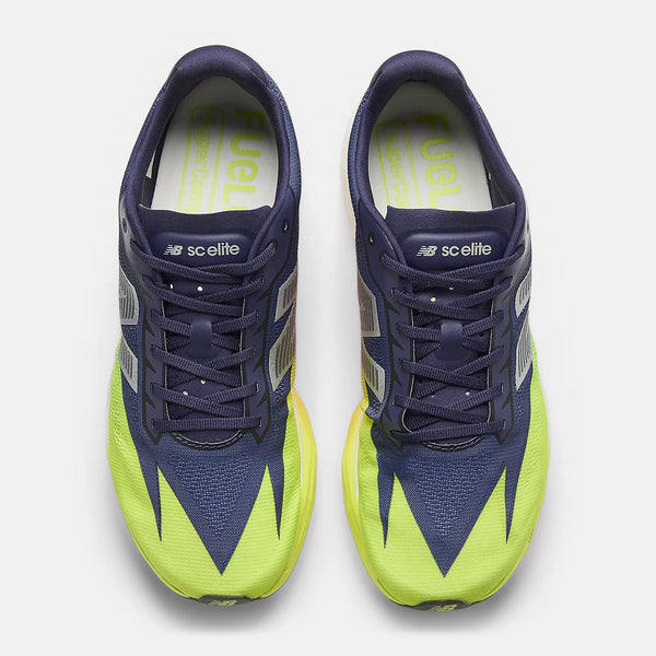 Navy and green running shoe with New Balance logo on a white background