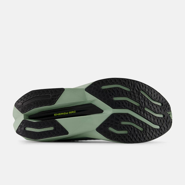 The outsole of a New Balance green running shoe with black sole on a white background